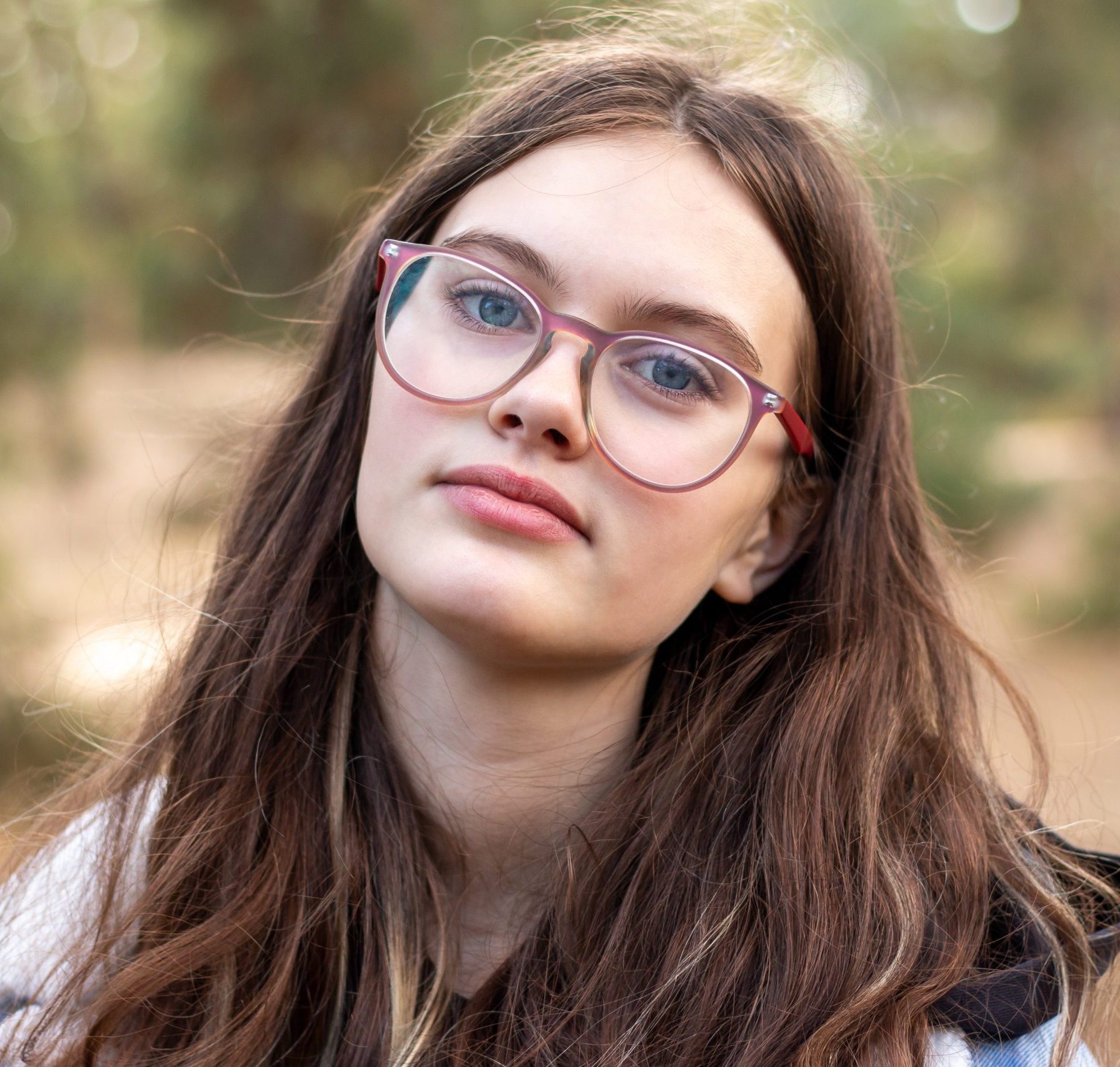 Porträt einer Frau mit braunen Haaren und Brille.