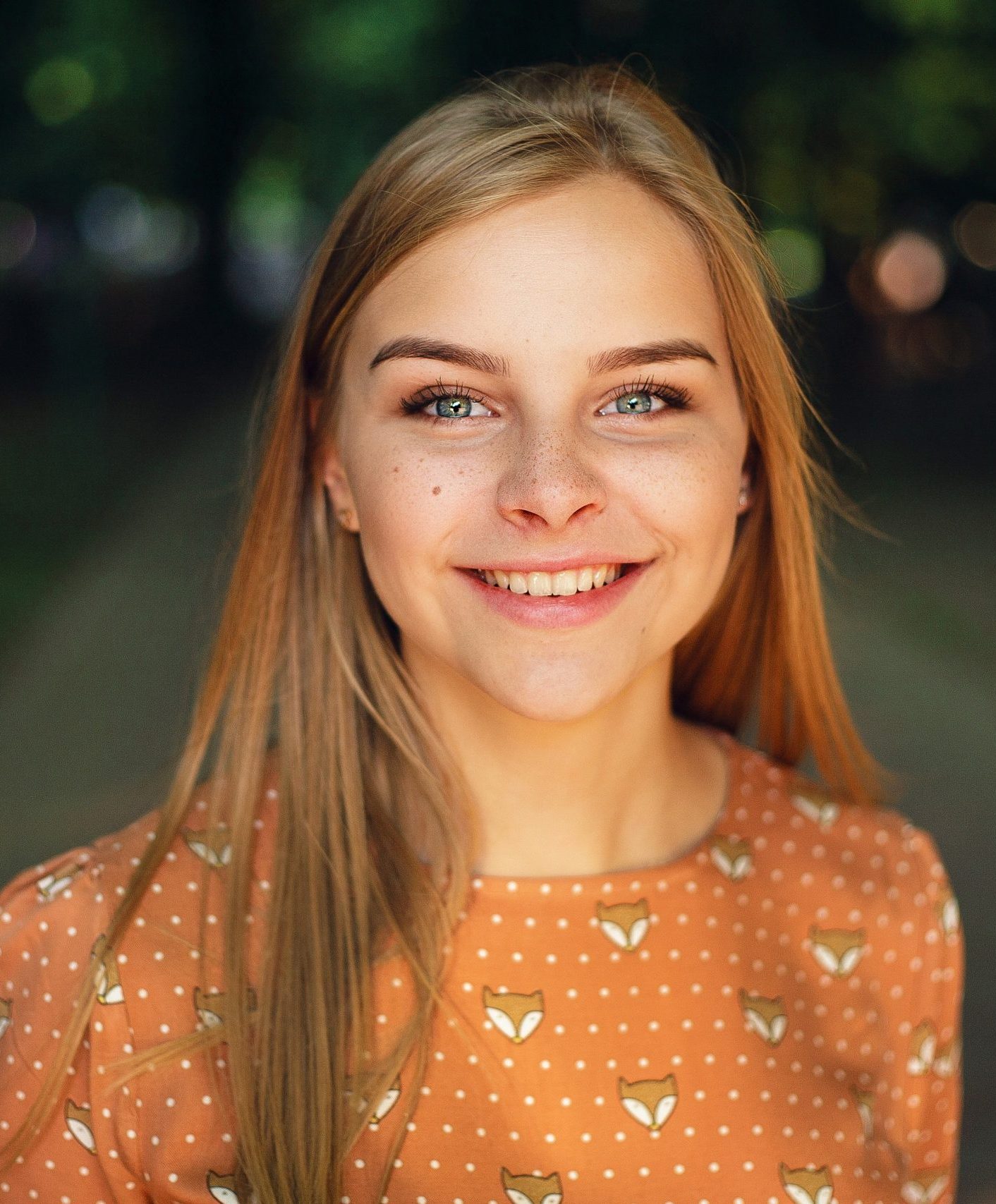 Portrait of a smiling woman with blue eyes and blonde hair.